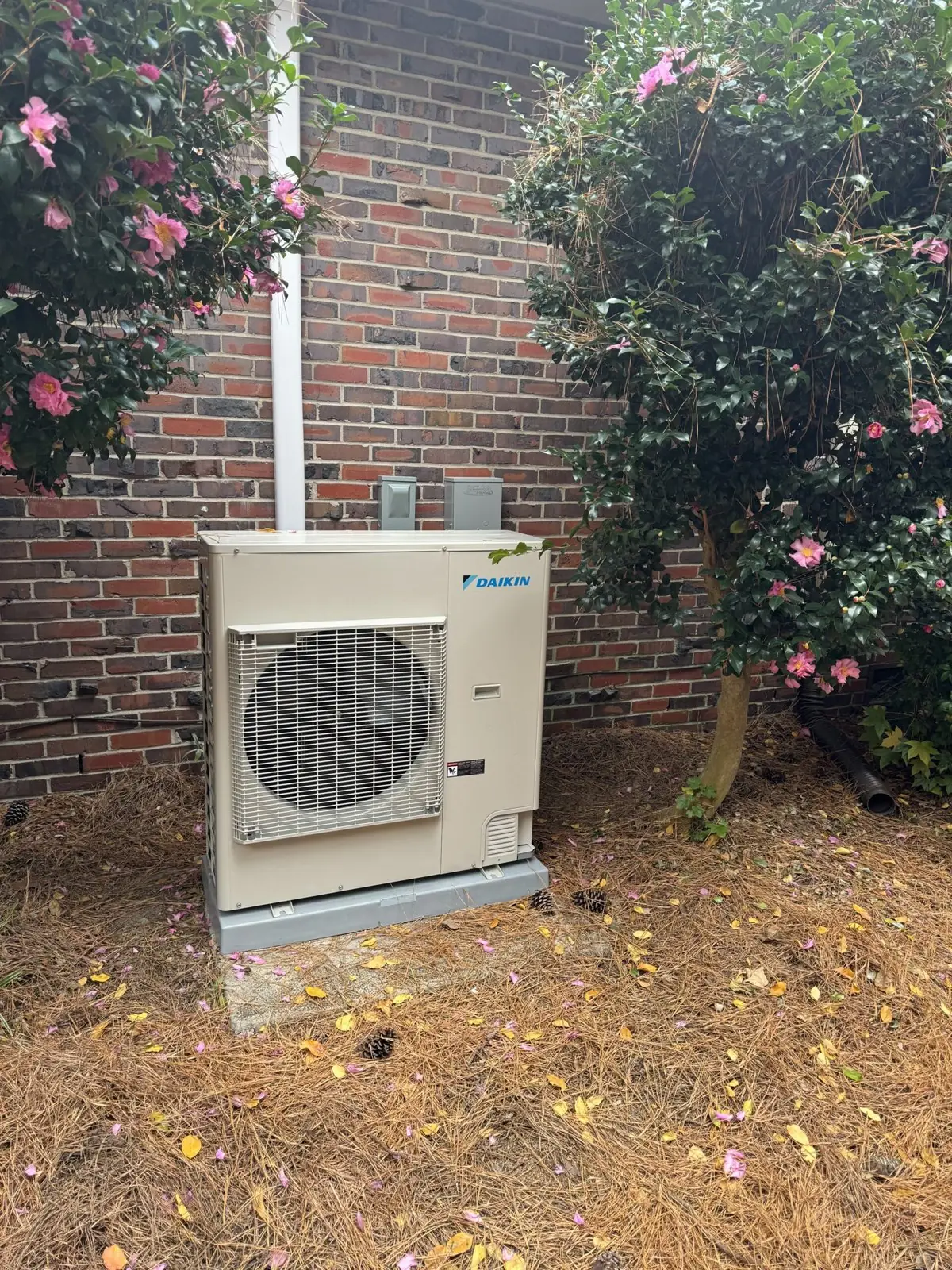 K&A Mechanical Daikin outdoor unit installation beside a brick home